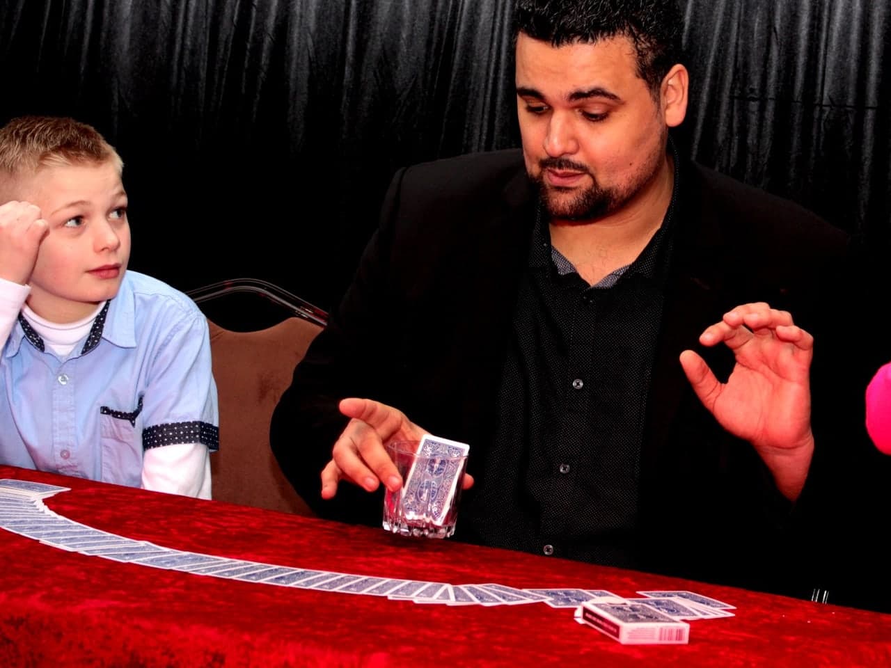 Jérémy Marouani réalisant un tour de cartes devant deux enfants captivés